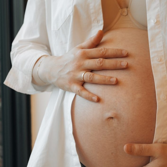 Frau tränenverschmierter Schminke hält ein Blatt mit einem lächelnden Gesicht vor sich.