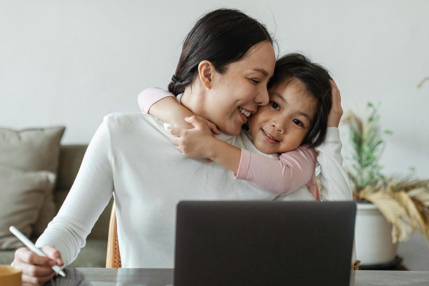 Ein Kind malt mit einer Farbpalette vor einer Leinwand in einem Atelier, die Mutter steht beratend daneben.
