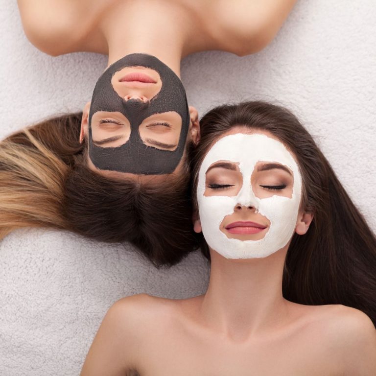 Zwei Frauen liegen nebeneinander mit Gesichtsmaske und haben entspannt die Augen geschlossen. ,
