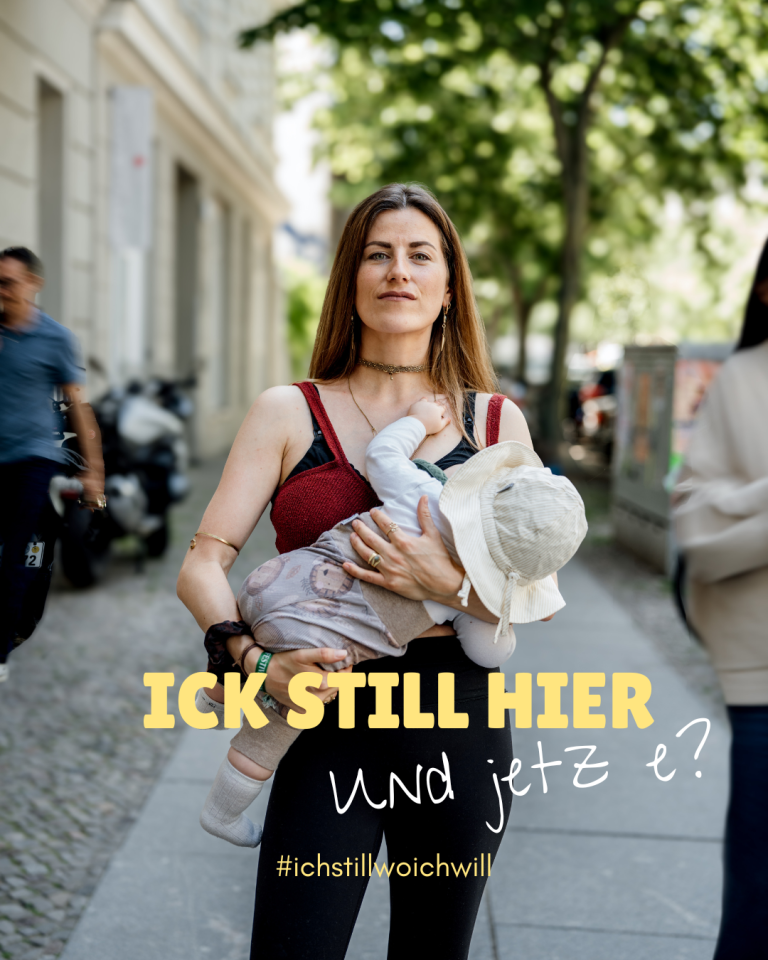 Foto: Lisa Lange, Lisa Lange Fotografie Frau stillt ihr Kind selbstbewusst auf der Straße, mit Schriftzug "Ich Still Wo Ich Will".
