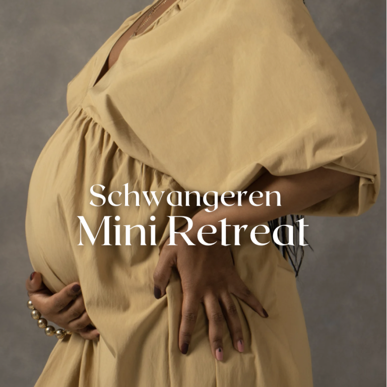 Schwangere Frau sitzt mit gefalteten Händen im Schneidersitz und lächelt entspannt.